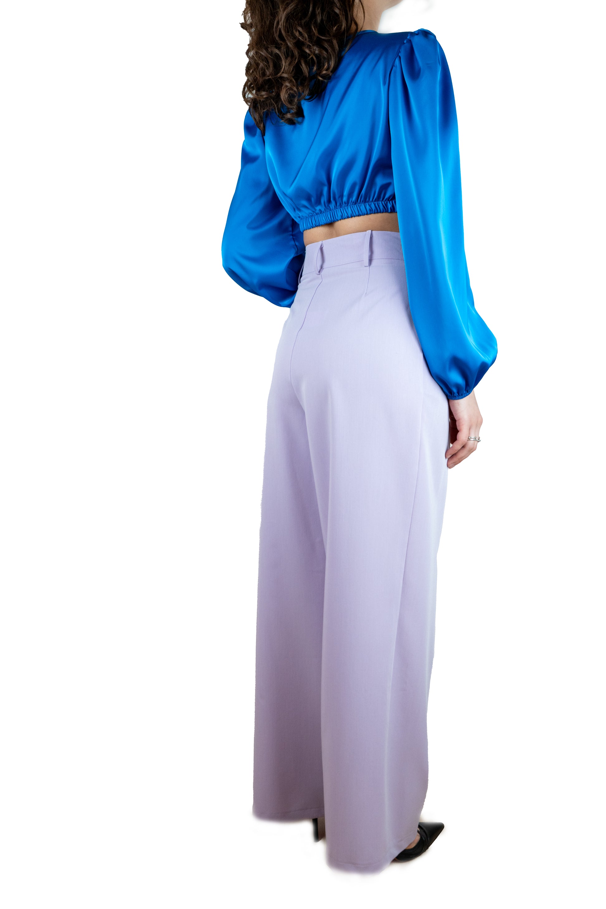 Camicia bluette cropped in raso con bottoni color oro, nodo frontale e manica a palloncino.